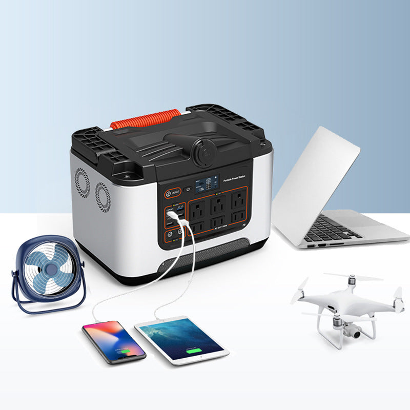 Portable Power Station Charging a Smartphone with Laptop, Fan, and Mini Drone Nearby